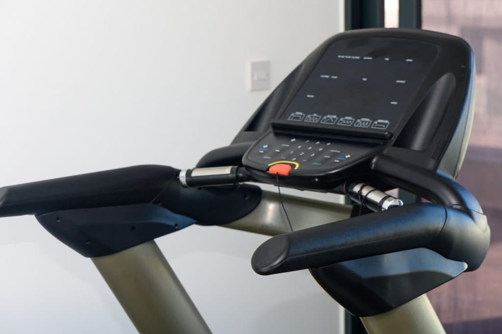 Rows of treadmills in a clean recreation facility gym